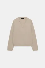 Jersey de punto confeccionado en lana 100%, con escote en pico y manga larga de corte holgado.