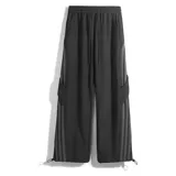 Pantalón deportivo negro de corte ancho y tiro alto con cordón ajustable en la cintura. Presenta tres franjas verticales grises oscuras en los laterales y un bolsillo cargo con solapa en el muslo derecho. Los tobillos son ajustables.