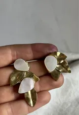Aros colgantes hechos a mano en bronce dorado con detalles de nácar.