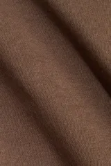 Buzo de felpa con interior cepillado, cuello redondo acanalado y mangas largas raglán. Presenta costuras moldeadoras en la cintura que crean una silueta entallada con efecto peplum.