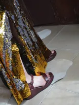 Sandalias de plataforma con taco cuña color marrón y tiras doradas metalizadas en el empeine y el talón. Cuentan con tira ajustable con hebilla metálica en el tobillo.