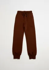 Pantalón deportivo tipo babucha color marrón, con cintura elástica ajustable mediante cordón y puños acanalados en los tobillos.