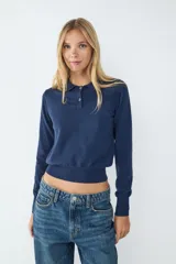 Suéter tejido color azul marino, con cuello estilo polo, escote en V y mangas largas. Confeccionado en un tejido suave y liviano.