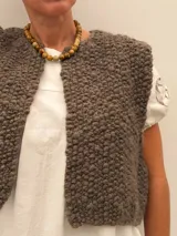 Collar de cuentas de piedras naturales en tonos tierra, con detalles de tubos dorados en los laterales.