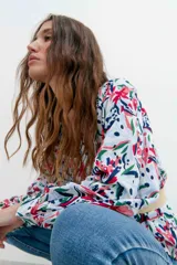 Blusa estampada con flores rojas, verdes y azules, escote en V y mangas balloon.