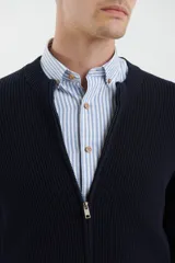 Cardigan de tejido de punto con cierre frontal completo, cuello redondo y bolsillos laterales. Presenta un diseño de textura acanalada y puños elásticos.