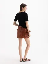 Top de punto morley color negro, con silueta ajustada al cuerpo, mangas cortas y escote redondo pronunciado.