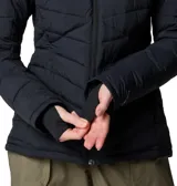 Campera acolchada de mujer con tecnología térmica, cierre frontal completo, cuello alto y puños con orificios para pulgares. Presenta un diseño de costuras horizontales y diagonales, con logo de la marca en el pecho.