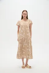 Vestido midi de viscosa con estampado floral en tonos celeste y blanco, cuello en V, mangas cortas y diseño holgado con volados escalonados en la falda.