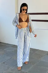 Pantalón casual de corte amplio con estampado de rayas verticales celestes y blancas, con cintura elastizada y cordón ajustable.
