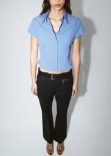 Pantalón de tiro bajo y diseño acampanado color negro, con trabillas para cinturón y bolsillos traseros ribeteados, confeccionado en mezcla de algodón elástico.