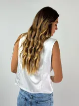 Chaleco blanco con escote en V y abotonadura frontal.