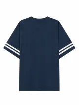 Remera blanca de corte oversize con estampado frontal estilo universitario que incluye el número 98 y el texto College League. Presenta mangas cortas con doble franja horizontal en color azul.