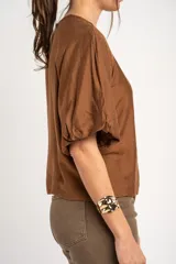 Blusa color marrón con mangas globo cortas y escote redondo.