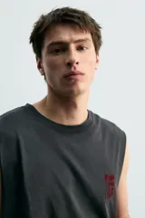 Musculosa de corte relajado en color negro con efecto lavado. Presenta cuello redondo, sisas amplias con acabado irregular y estampado gráfico de Jurassic Park en el frente y la espalda.