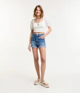 Short de jean de tiro alto, color azul medio, con trabillas en la cintura, cierre con botón y cremallera, bolsillos delanteros y traseros, y ruedo con dobladillo.