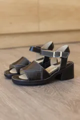 Sandalias de cuero color marrón, con faja frontal ancha con detalle de textura en relieve, plataforma sutil, taco ancho y pulsera ajustable con hebilla en el tobillo.