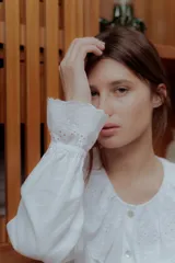 Camisa blanca de lino con cuello babero de broderie y mangas largas.