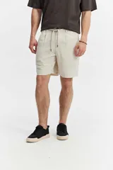 Bermuda estilo chino confeccionada en mezcla de lino y algodón, color azul melange, de corte suelto, cintura elastizada con cordón ajustable y pinzas delanteras.