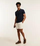 Polo de hombre marca Marfinno, confeccionada en tejido de media malla con textura rayada. Presenta cuello polo con botones y mangas cortas con terminaciones en rib con detalles contrastantes.