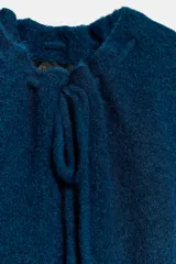 Jersey de punto de textura suave en color azul, con cuello redondo ajustable mediante cordones del mismo tejido y manga corta.