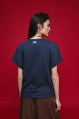 Remera negra de manga corta con cuello redondo y silueta amplia, de hombros caídos y textura suave.