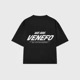 Remera negra de corte oversize con estampa gráfica en la espalda en color crema que incluye el texto 'WE ARE VENEFO' y una frase secundaria. Confeccionada en algodón de alta calidad.