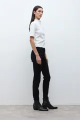 Pantalón slim fit color negro, con cierre de botón y cremallera, y bolsillos traseros.