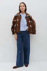 Pantalón de jean azul de corte recto y tiro alto, con costuras verticales decorativas en el frente y botamanga ancha.