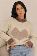 Sweater de lana merino color beige, con diseño tejido de punto jacquard estilo nórdico en tonos marrón, negro, blanco y lila en el pecho y las mangas. Cuenta con cuello redondo, puños y dobladillo acanalados.