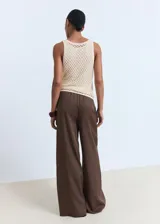 Pantalón wide leg de tiro medio color marrón, confeccionado en lyocell con forro de viscosa. Cuenta con cintura elástica con cordón ajustable y dos bolsillos laterales.
