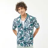 Camisa de manga corta con estampado de hojas y flores en tonos verde, azul y blanco. Tiene cuello clásico y cierre frontal con botones.