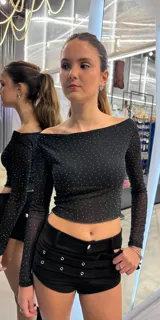 Short negro de tiro bajo confeccionado en material engomado, con diseño de doble cinturón integrado con ojales metálicos y hebillas laterales.