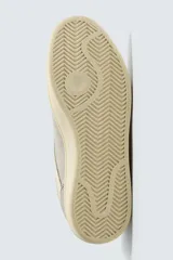 Zapatilla de estilo retro con cordones, confeccionada en una combinación de piezas de gamuza y material sintético. Presenta suela de goma a contraste y diseño de paneles laterales.