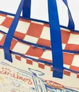 Bolsa de compras amplia de formato rectangular, confeccionada en material plástico resistente. Presenta un diseño a cuadros en tonos blanco y rojo, con asas dobles reforzadas y ribetes en color azul. Cuenta con una gran ilustración frontal estilo ilustración de lata de sardinas y detalles de texto.