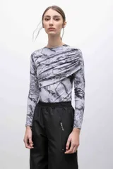 Top de jersey tricot suplex con estampado de mármol en tonos grises. Diseño ajustado con frunces diagonales en el frente y mangas largas.