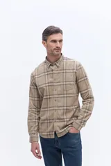 Camisa de manga larga confeccionada en viyela de algodón con diseño a cuadros en tonos verde oscuro. Presenta cuello clásico, cierre frontal con botones y bolsillo aplicado en el pecho.