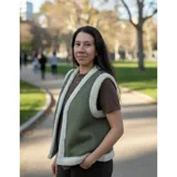 Chaleco estilo gamulán color verde militar con forro y bordes de corderito sintético blanco, diseño sin mangas.