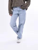Jean de corte mom fit en color celeste claro, tiro medio-alto, con diseño clásico de cinco bolsillos y pernera recta ligeramente cónica.