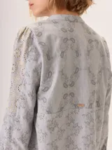 Camisa de algodón con diseño de bloques de color en tonos marrón, rosa y lila. Presenta cuello redondo, cierre frontal con botones y mangas largas.