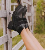 Bota corta de cuero vacuno color negro, con suela de caucho tipo tractor y cierre mediante doble tira de velcro en el empeine.