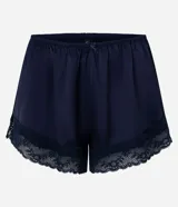 Short de pijama azul marino de satén con acabado brillante y caída fluida, cintura elastizada con moño decorativo y detalles de encaje en los bajos.