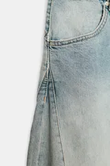 Jeans de mezclilla de tiro medio con diseño amplio tipo balloon, costuras marcadas y bajo con puño elástico. Cuenta con bolsillos delanteros y traseros, y cierre frontal con cremallera y botón metálico.