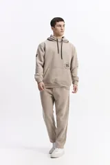 Canguro con capucha y cordones ajustables en color beige, con diseño de calce regular y estampado frontal pequeño.