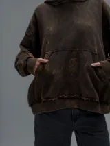Hoodie oversize de algodón con efecto desgastado y oxidado. Presenta costuras expuestas, detalles de roturas en los bordes, capucha y bolsillo frontal tipo canguro.
