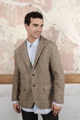 Saco sport marrón claro con medio forro, botones y coderas de cuero. Corte holgado, ideal para combinar con pantalón de vestir o jeans. Confeccionado en Uruguay con tela 100% lana fina sin teñir.