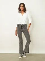 Jean de corte oxford en color negro, con tiro medio y ajuste en la cintura y caderas, ensanchándose desde la rodilla hacia el ruedo.