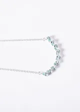 Collar de plata 925 con cadena forcé y una hilera de piedras de topacio celeste talladas en forma de gota, dispuestas en forma de arco.