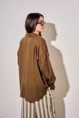 Camisa de lino y viscosa color marrón, con bolsillos frontales ojal, mangas largas y corte oversize.