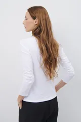 Remera de manga larga con escote en V, confeccionada en algodón de doble capa con textura suave y ajuste al cuerpo.